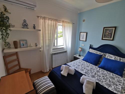 a bedroom with a blue bed and a window at Casa Colina Troviscainho in Sertã
