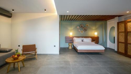 a bedroom with a bed and a couch and a table at Amyntas Seafront Hotel in Neos Marmaras
