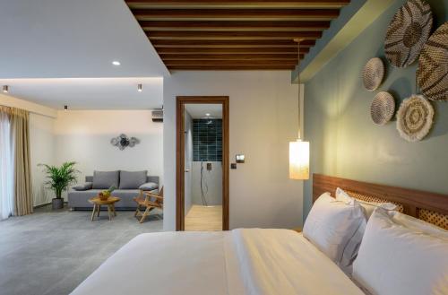 a bedroom with a bed and a living room at Amyntas Seafront Hotel in Neos Marmaras