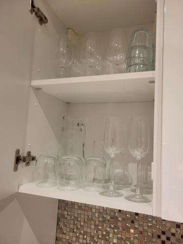 Un mucchio di bicchieri da vino seduti su uno scaffale. di Duplex neuf 2 chambres HUY a Huy