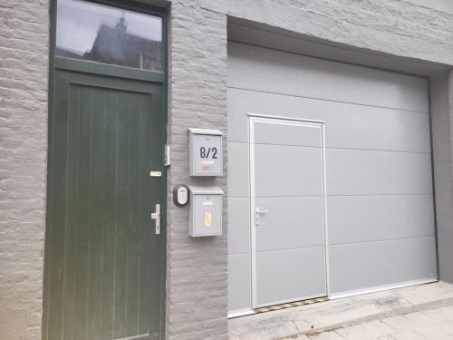 a garage with a green and white garage door at Duplex neuf 2 chambres HUY in Huy