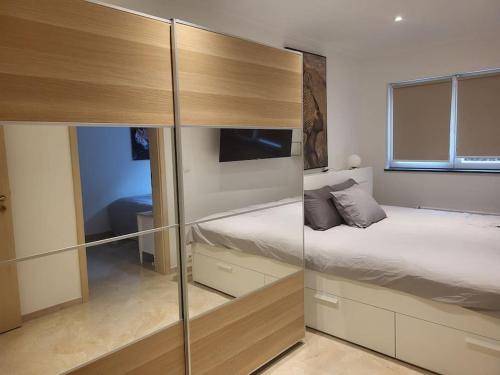 um quarto com uma cama e uma parede de vidro deslizante em Duplex neuf 2 chambres HUY em Huy
