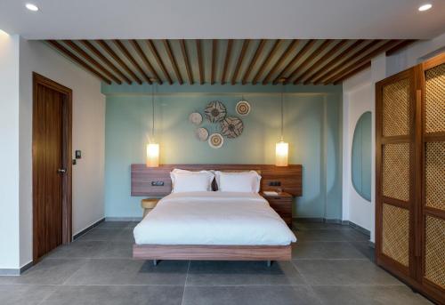 a bedroom with a large white bed with two pillows at Amyntas Seafront Hotel in Neos Marmaras