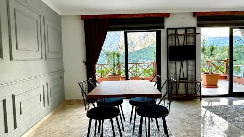 a dining room with a table and chairs and a large window at Villa Taş Konak in Gedeller