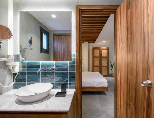 a bathroom with a sink and a bed in a room at Amyntas Seafront Hotel in Neos Marmaras