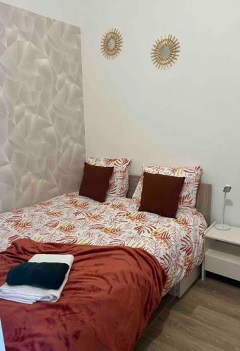 1 dormitorio con cama con edredón y almohadas rojos en Bel appartement moderne, en Marly
