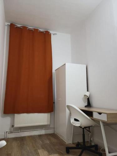 un bureau avec un bureau et une chaise à côté d'une fenêtre dans l'établissement Bel appartement moderne, à Marly