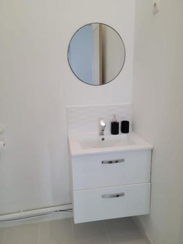 y baño con lavabo blanco y espejo. en Bel appartement moderne, en Marly