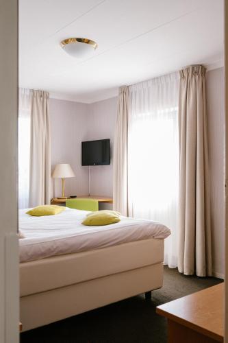 a bedroom with a bed and a large window at Landhotel Heuvelzicht in Schin op Geul