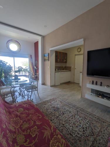 Il comprend un salon avec une télévision à écran plat et une salle à manger. dans l'établissement Havre de Paix sur la Côte Bleue, à Sausset-les-Pins