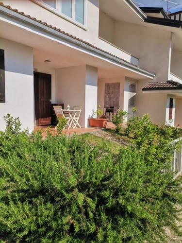 a house with bushes in front of a yard at Soggiorno rilassante in montagna in Riolunato