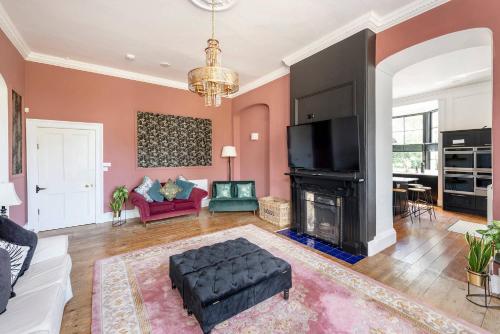 a living room with a couch and a fireplace at Historic country house retreat with hot tub, ideal for large groups in Petty France