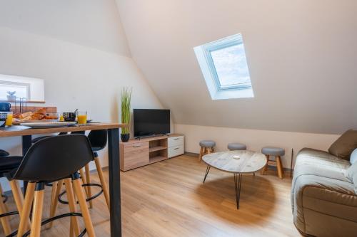 uma sala de estar com uma mesa e um sofá em Le Point Sublime - Netflix/Wifi Fibre/Terrasse em Banassac