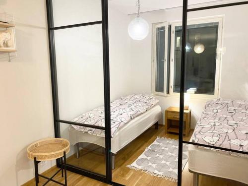 um pequeno quarto com uma cama e uma caixa de vidro em JATKASAARI-1 Dream stay on Helsinki seafront em Helsinque