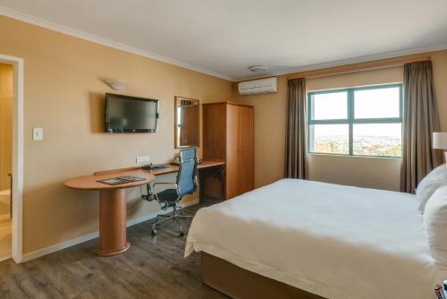 a hotel room with a bed and a desk at Protea Hotel by Marriott Cape Town Tyger Valley in Bellville