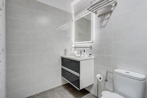 W łazience znajduje się toaleta, umywalka i lustro. w obiekcie Drilasol Seaview 1A022 w mieście Puerto de Santiago