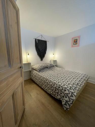 a bedroom with a bed with a black and white comforter at Spacieux appartement à Blois avec Wifi gratuit in Blois