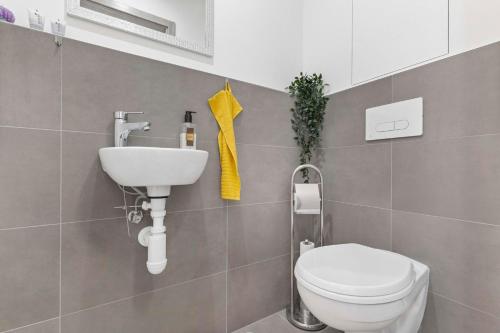 a bathroom with a toilet and a sink at Air-conditioned 75m2 apartment next to the airport - FREE PARKING in Prievoz