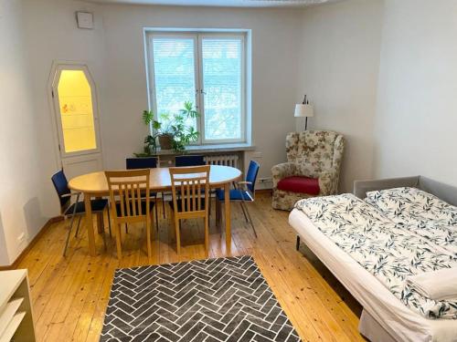 a living room with a dining room table and a bed at KAMPPI 1 - Perfect location right in Helsinki center in Helsinki