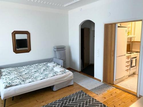 a white bedroom with a bed and a kitchen at KAMPPI - Perfect location right in Helsinki center in Helsinki