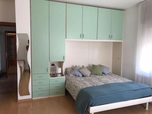 - une chambre avec un lit et des armoires bleues dans l'établissement appartamento IL SOLE, à Mel