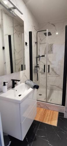 une salle de bain avec un lavabo blanc et une douche dans l'établissement Golden - Éden - superbe 2 pièces de standing en hypercentre, à Vichy