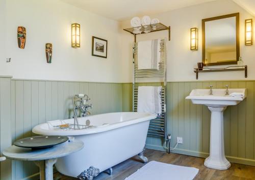 a bathroom with a tub and a sink at Woodberry Cottage in Dunwich