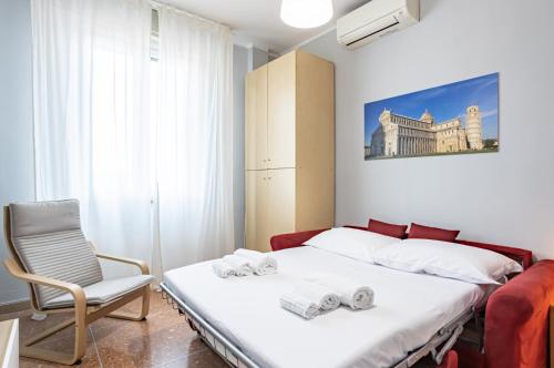 1 dormitorio con 1 cama y 1 silla en Yellowsunny Apartment with Two Balconies, en Pisa