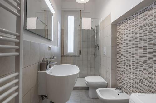 Baño blanco con lavabo y aseo en Yellowsunny Apartment with Two Balconies, en Pisa