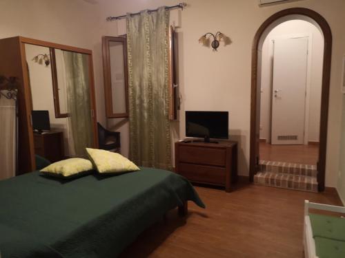 a bedroom with a green bed and a television at Casa Indipendente in Villa San Giovanni