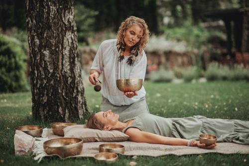 a woman standing over a woman laying on the grass at "Parko vila" Anykščiai in Anykščiai