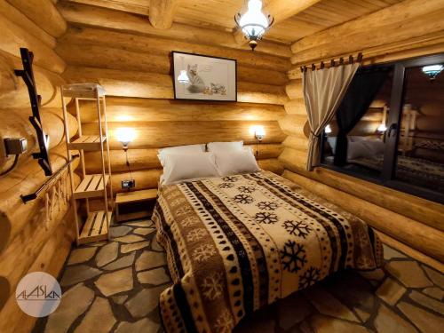 1 dormitorio con 1 cama en una cabaña de madera en Cabana Alaska en Ranca