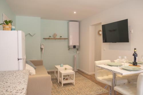een woonkamer met een tafel en een woonkamer met een tv bij Nouveau - Entre Terre et Mer - Centre Ville in Saverne