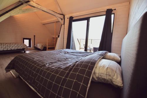 łóżko w pokoju z dużym oknem w obiekcie Hoppezicht w mieście Proven