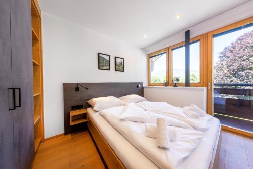 duże łóżko w pokoju z dużym oknem w obiekcie Appartement Gernkogelblick w mieście Wald im Pinzgau
