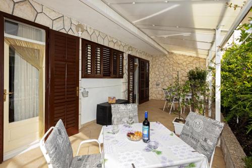 una mesa y sillas en un patio con una botella de vino en Apartments Balić, en Hvar
