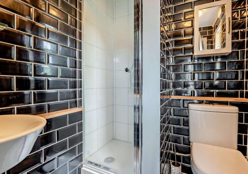 een badkamer met een douche, een toilet en een wastafel bij Tiggywinkles in Debenham