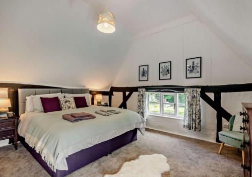 een slaapkamer met een groot bed en een raam bij Walnut Cottage - Suffolk in Rumburgh