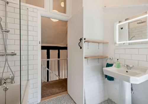 a small bathroom with a sink and a shower at Walnut Cottage - Suffolk in Rumburgh