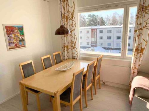 comedor con mesa, sillas y ventana en MELLUNMAKI Renovated 3 bedroom apt next to metro, en Helsinki