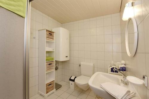 biała łazienka z toaletą i umywalką w obiekcie Ferienwohnung Bitschnau Ulrike w mieście Vandans