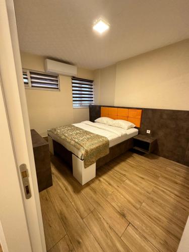 sypialnia z łóżkiem i drewnianą podłogą w obiekcie Ale Boutique Apartments w mieście Antalya