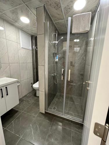 W łazience znajduje się prysznic ze szklanymi drzwiami. w obiekcie Ale Boutique Apartments w mieście Antalya