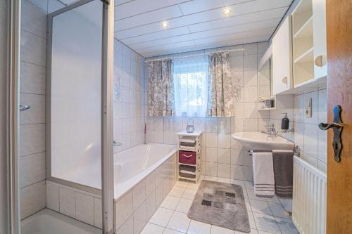 een badkamer met een bad en een wastafel bij Burger Elisabeth in Sankt Gallenkirch