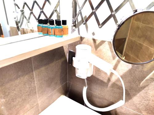 une salle de bain avec un distributeur de savon et un miroir dans l'établissement Galata World Hotel, à Istanbul