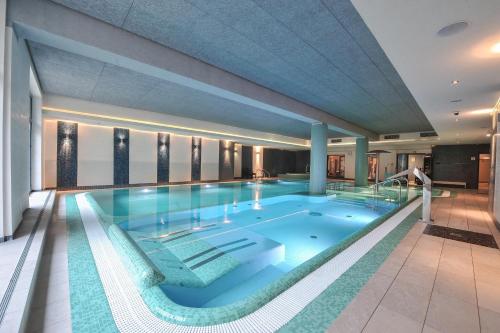 a large swimming pool in a building at Hotel Młyn Aqua Spa Biblioteka in Elblag