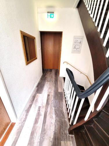 a stairway with a black chair in a hallway at City Center Hotel Garni Cuxhaven in Cuxhaven