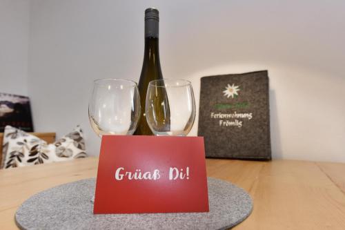 a bottle of wine and two wine glasses on a table at Ferienwohnung Frömlig in Silbertal