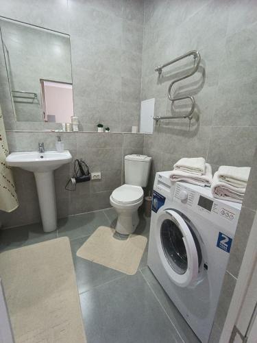 a bathroom with a washing machine and a sink at Altyn Dala in Taldykolʼ