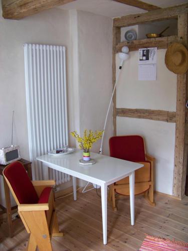 einen weißen Tisch und Stühle in einem Zimmer in der Unterkunft Gemütliches kleines Studio in Alt Sassnitz in Sassnitz